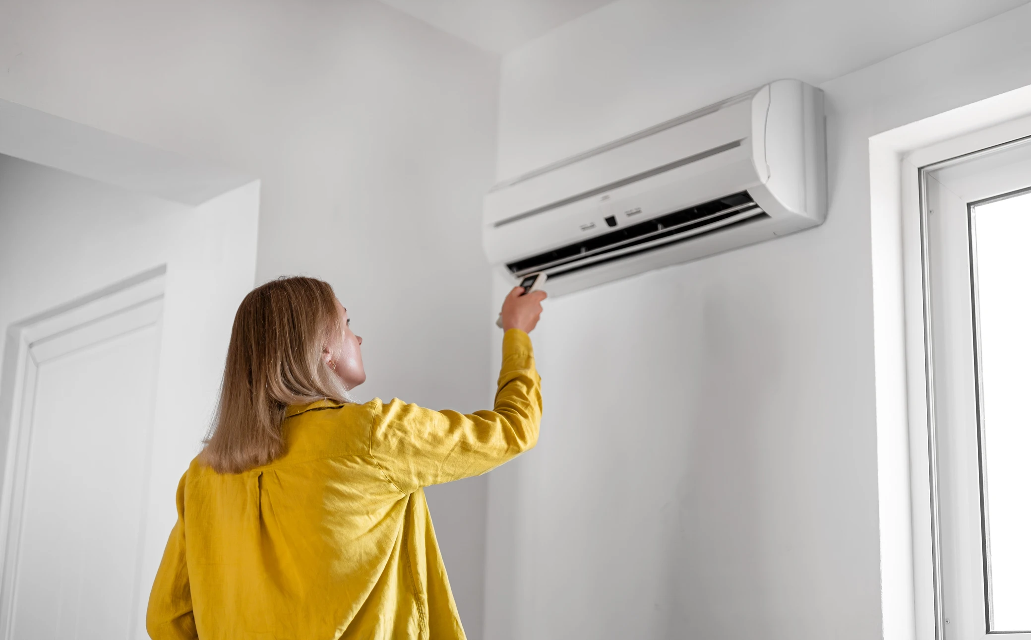 Un technicien travaillant sur la climatisation ou la pompe à chaleur d'une unité extérieure
